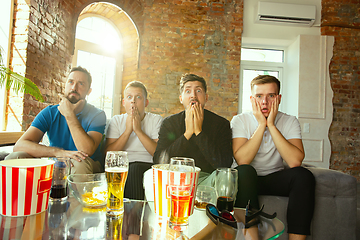 Image showing Group of friends watching football or soccer game on TV at home