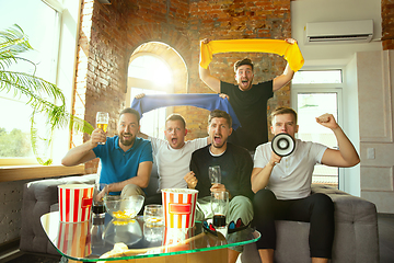 Image showing Group of friends watching football or soccer game on TV at home