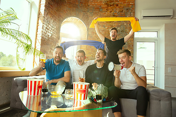 Image showing Group of friends watching football or soccer game on TV at home