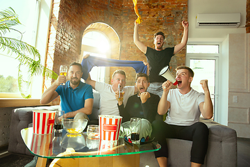 Image showing Group of friends watching football or soccer game on TV at home