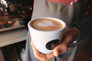 Image showing Stylish black espresso making machine, shooted in cafe. Close-up shot of barista hands