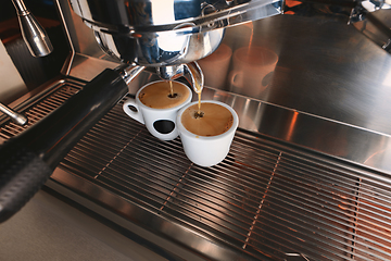 Image showing Stylish black espresso making machine brewing two cups of coffee, shooted in cafe.