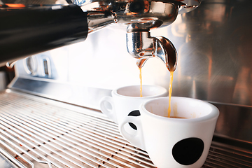 Image showing Stylish black espresso making machine brewing two cups of coffee, shooted in cafe.