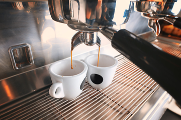 Image showing Stylish black espresso making machine brewing two cups of coffee, shooted in cafe.