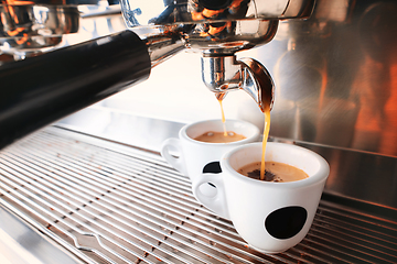 Image showing Stylish black espresso making machine brewing two cups of coffee, shooted in cafe.