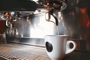 Image showing Stylish black espresso making machine brewing two cups of coffee, shooted in cafe.