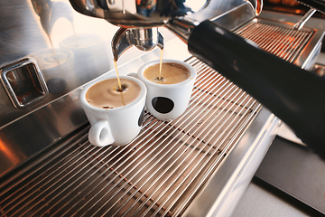 Image showing Stylish black espresso making machine brewing two cups of coffee, shooted in cafe.