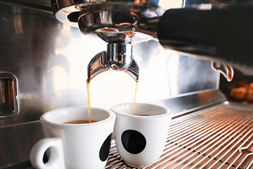 Image showing Stylish black espresso making machine brewing two cups of coffee, shooted in cafe.