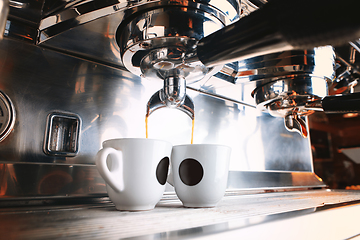 Image showing Stylish black espresso making machine brewing two cups of coffee, shooted in cafe.