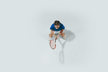 Image showing Young woman in blue shirt playing tennis. Youth, flexibility, power and energy.