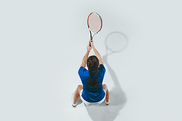 Image showing Young woman in blue shirt playing tennis. Youth, flexibility, power and energy.