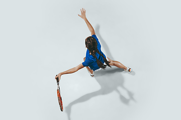 Image showing Young woman in blue shirt playing tennis. Youth, flexibility, power and energy.