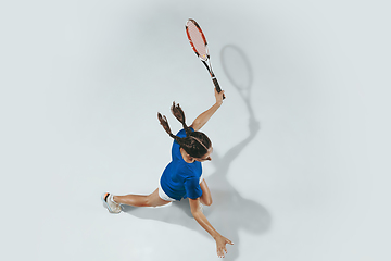 Image showing Young woman in blue shirt playing tennis. Youth, flexibility, power and energy.