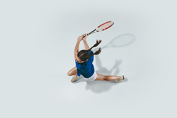 Image showing Young woman in blue shirt playing tennis. Youth, flexibility, power and energy.