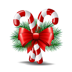 Image showing Christmas candy canes with red bow isolated on white.