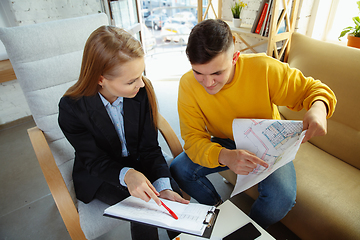Image showing Interior designer working with young couple. Lovely family and professional designer or architector.