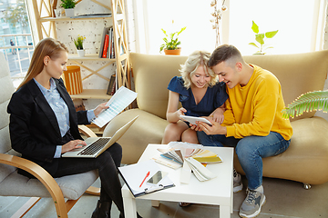 Image showing Interior designer working with young couple. Lovely family and professional designer or architector.