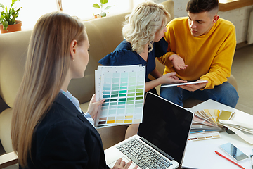 Image showing Interior designer working with young couple. Lovely family and professional designer or architector.