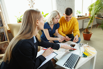 Image showing Interior designer working with young couple. Lovely family and professional designer or architector.