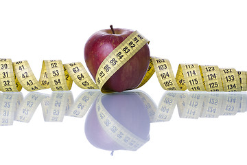 Image showing Red apple over a measure tape