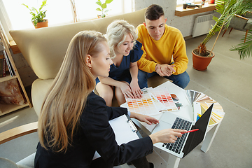 Image showing Interior designer working with young couple. Lovely family and professional designer or architector.