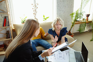 Image showing Interior designer working with young couple. Lovely family and professional designer or architector.