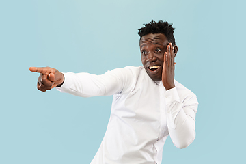 Image showing Young african-american man isolated on blue studio background, human emotions concept.