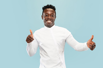 Image showing Young african-american man isolated on blue studio background, human emotions concept.