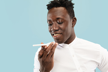 Image showing Young african-american man isolated on blue studio background, human emotions concept.