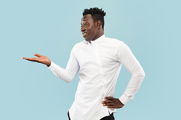 Image showing Young african-american man isolated on blue studio background, human emotions concept.