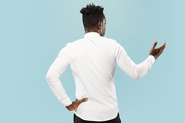 Image showing Young african-american man isolated on blue studio background, human emotions concept.