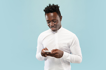 Image showing Young african-american man isolated on blue studio background, human emotions concept.