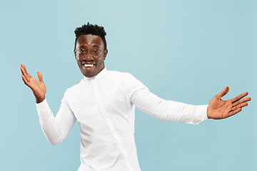 Image showing Young african-american man isolated on blue studio background, human emotions concept.