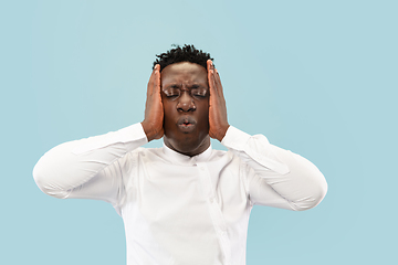 Image showing Young african-american man isolated on blue studio background, human emotions concept.