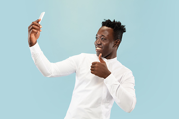 Image showing Young african-american man isolated on blue studio background, human emotions concept.