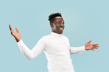 Image showing Young african-american man isolated on blue studio background, human emotions concept.