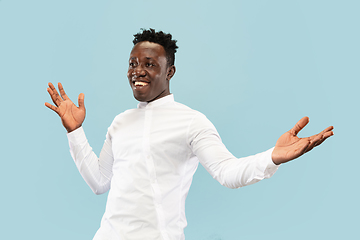 Image showing Young african-american man isolated on blue studio background, human emotions concept.