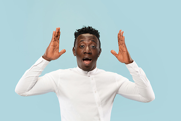 Image showing Young african-american man isolated on blue studio background, human emotions concept.