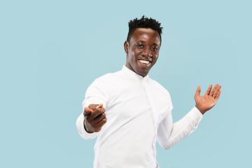 Image showing Young african-american man isolated on blue studio background, human emotions concept.