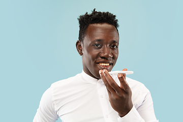 Image showing Young african-american man isolated on blue studio background, human emotions concept.