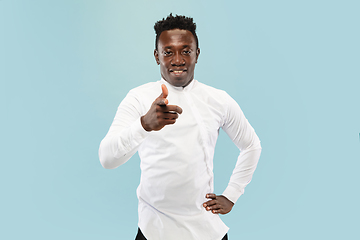 Image showing Young african-american man isolated on blue studio background, human emotions concept.