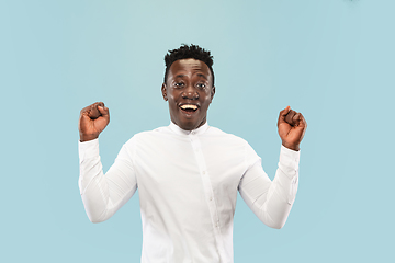 Image showing Young african-american man isolated on blue studio background, human emotions concept.