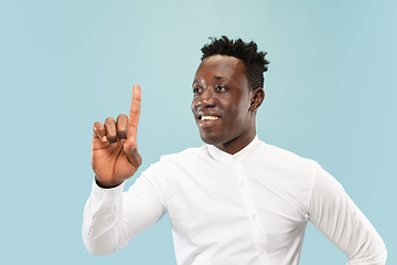 Image showing Young african-american man isolated on blue studio background, human emotions concept.