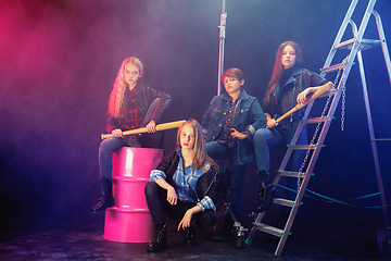 Image showing Full length portrait of cute little kids in stylish jeans clothes looking at camera and smiling, standing against white brick wall