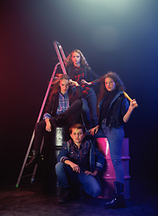 Image showing Full length portrait of cute little kids in stylish jeans clothes looking at camera and smiling, standing against white brick wall