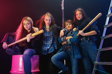 Image showing Full length portrait of cute little kids in stylish jeans clothes looking at camera and smiling, standing against white brick wall