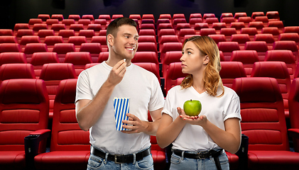 Image showing couple with popcorn and apple at cinema