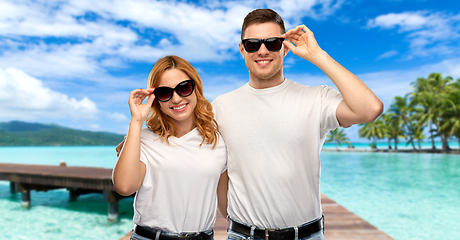 Image showing happy couple in t-shirts and sunglasses on beach