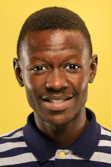 Image showing African-american young man\'s close up portrait on yellow background