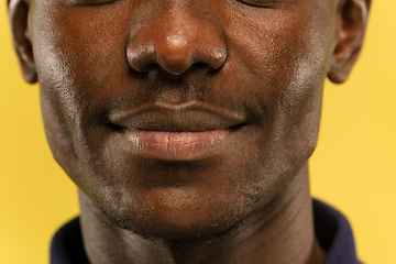 Image showing African-american young man\'s close up portrait on yellow background